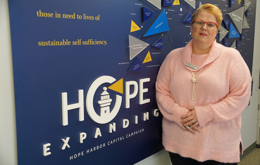 Renae Swanson in front of Hope Harbor sign